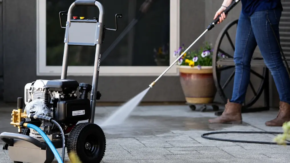 Pressure washer wand, hose, and protective safety gear staged for a job